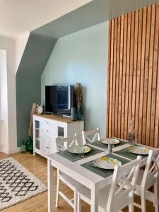 une salle à manger avec une table et des chaises blanches dans l'établissement Le Citronnier, à Fouesnant