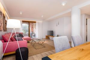 a living room with a pink couch and chairs at Lola's Luxury Apartments in Liapades +30 photos