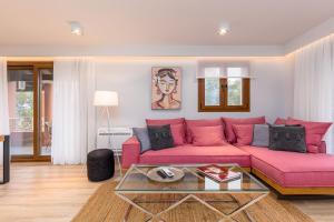 sala de estar con sofá rosa y mesa de cristal en Lola's Luxury Apartments, en Liapades