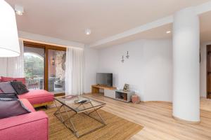 uma sala de estar com um sofá rosa e uma mesa em Lola's Luxury Apartments em Liapades