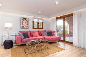 sala de estar con sofá rosa y mesa en Lola's Luxury Apartments, en Liapades