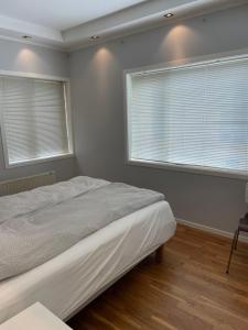ein Schlafzimmer mit einem Bett und zwei Fenstern in der Unterkunft Eiganesveien 1 in Stavanger