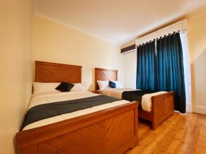 um quarto com 2 camas e uma janela com cortinas azuis em Cairo House Hostel no Cairo