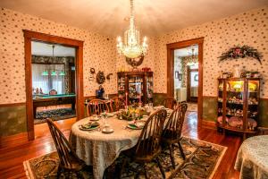uma sala de jantar com uma mesa e cadeiras e um lustre em Hollerstown Hill Bed and Breakfast em Frederick