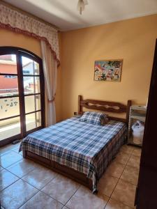 een slaapkamer met een bed en een groot raam bij Casa Inteira Família próxima ao Santuário Nacional in Aparecida