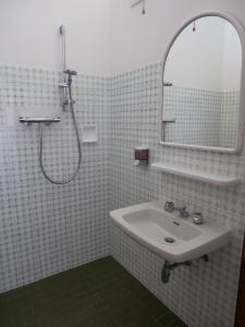 ein Bad mit einem Waschbecken und einer Dusche mit einem Spiegel in der Unterkunft Hotel Pari in Misano Adriatico