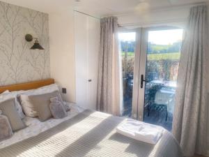 a bedroom with a bed and a large window at The Hoppers' Halt in Staplehurst