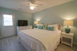 um quarto com uma cama, uma ventoinha de tecto e uma televisão em Atlantic Sunrise em Tybee Island