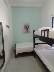Habitación con 3 literas y espejo. en 2AG-1M CASA DE 2 HABITACIONES EN GETSEMANI CON JACUZZI Y WIFI, en Cartagena de Indias