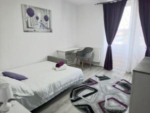ein Schlafzimmer mit zwei Betten und einem Tisch und einem Stuhl in der Unterkunft Apartament BriFla Comfort Mureș in Târgu Mureș
