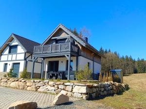 a large white house with a stone wall at Magiczne Miejsce in Szklarska Poręba