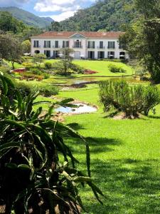 ペトロポリスにあるCasa 16 da Villa - Fazenda Marambaiaの草原付きの白い大きな建物