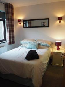 Schlafzimmer mit einem Bett und einem Wandspiegel in der Unterkunft Fern Lodge Angus, Kirriemuir in Region Angus