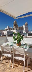 a white table and chairs with a view of the city at El 2 de Flamenco Ático 3ºA in Cádiz