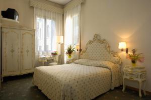 una camera da letto con un letto e una grande finestra di Albergo Basilea a Venezia