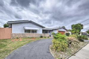 a white house with a fence and a driveway at Private Pool and Dock Coconut Creek Home! in Coconut Creek