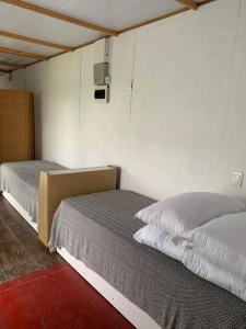 Habitación con 2 camas en una habitación en Casa Contenedor y espacio verde, en Paysandú
