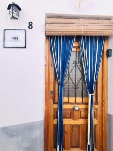 una puerta de madera con cortinas azules delante de ella en La Alkarra, en Alcalá del Júcar