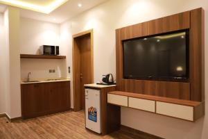 Habitación de hotel con TV de pantalla plana grande en la pared en Tulip View Hotel, en Khamis Mushayt