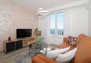 杜布罗夫尼克Blue Cliff Apartment的客厅里有一张沙发和一台电视