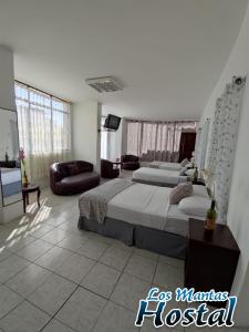 1 dormitorio con 2 camas y sala de estar en Hostal Los Mantas, en Manta