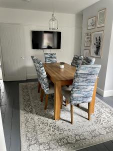 uma sala de jantar com uma mesa de madeira e cadeiras em Modernised Cottage in the Heart of Sketty em Swansea