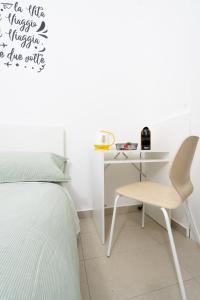 卡塔尼亞的住宿－Be happy Rooms，一间卧室配有一张床、一张桌子和一把椅子