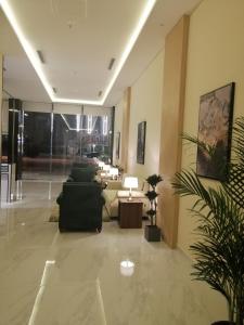 فندق توليب فيو في خميس مشيط: غرفة معيشة مع كنب وطاولات في مبنى