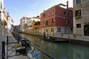una gondola su un canale in una città di Albergo Basilea a Venezia