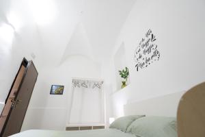 Habitación blanca con 2 camas y puerta en Be happy Rooms en Catania