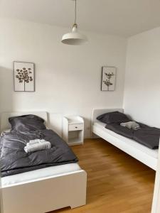 a bedroom with two beds and a night stand at Zentral, gemütlich, Messe nah! BE1L in Essen