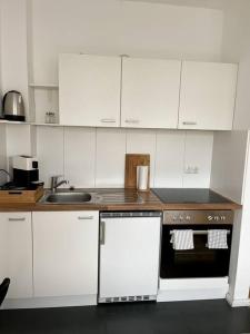 a kitchen with white cabinets and a stove top oven at Zentral, gemütlich, Messe nah! BE1L in Essen