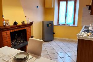 uma cozinha com um frigorífico ao lado de uma lareira em Casa Elena in Chianni em Chianni
