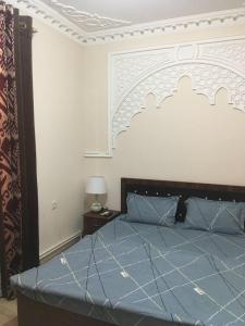 1 dormitorio con cama azul y cabecero grande en Uzbek House, en Samarkand