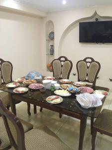 una mesa de comedor con platos de comida. en Uzbek House, en Samarkand