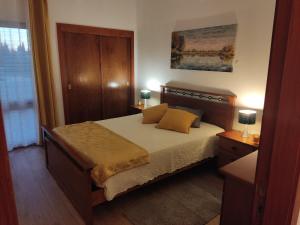 a bedroom with a bed with yellow pillows on it at Vieira apartment 1 in Quarteira