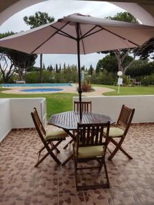a table and two chairs under an umbrella at Vieira apartment 1 in Quarteira