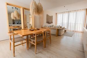 a kitchen and dining room with a wooden table and chairs at Lumina at The Village Luxury Residences in Corasol in Playa del Carmen