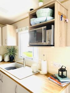 a kitchen with a sink and a microwave at Sea Breeze in Scarborough