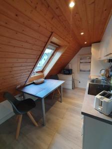 Antonshöhe的住宿－Ferienwohnung Hänel，一个小房子里一个带蓝色桌子的小厨房