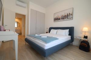 una camera con letto con testata blu di Apartments Royal - Belgrade Waterfront a Belgrado