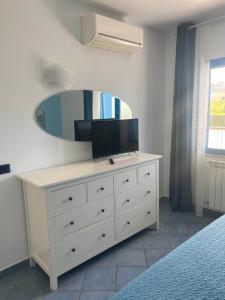 a bedroom with a dresser with a mirror on it at Residenza Le Spiagge in Sperlonga