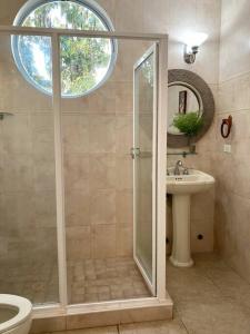 uma casa de banho com um chuveiro e um lavatório. em Amazing Beachfront Villa - Palm House em Punta Chame