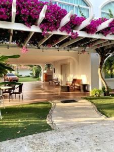 un patio con flores púrpuras en un edificio en Amazing Beachfront Villa - Palm House, en Punta Chame