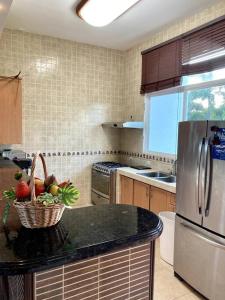 蓬塔查梅的住宿－Amazing Beachfront Villa - Palm House，厨房在柜台上摆放着一篮水果