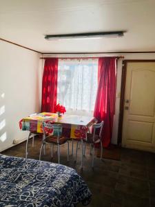 a room with a table and chairs and a window at Departamento Eusebio Lillo in Coihaique