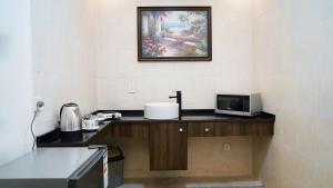 una cocina con encimera con microondas y una pintura en Sorate Hotel Apartment en Amán