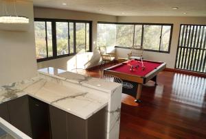 a kitchen with a ping pong table in a room at Residencia y piscina climatizada in La Venta del Astillero