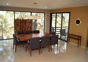 a dining room with a wooden table and chairs at Residencia y piscina climatizada in La Venta del Astillero