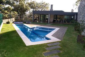 a swimming pool in the yard of a house at Residencia y piscina climatizada in La Venta del Astillero